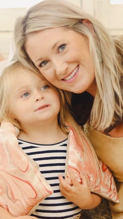 Woman and child sitting on a couch with comfort neck wraps on neck.